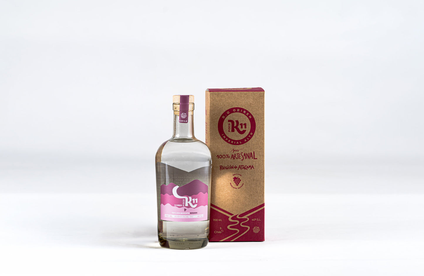 Botella de Pisco K11 Moscatel Rosada 700ml junto a su caja de packaging artesanal